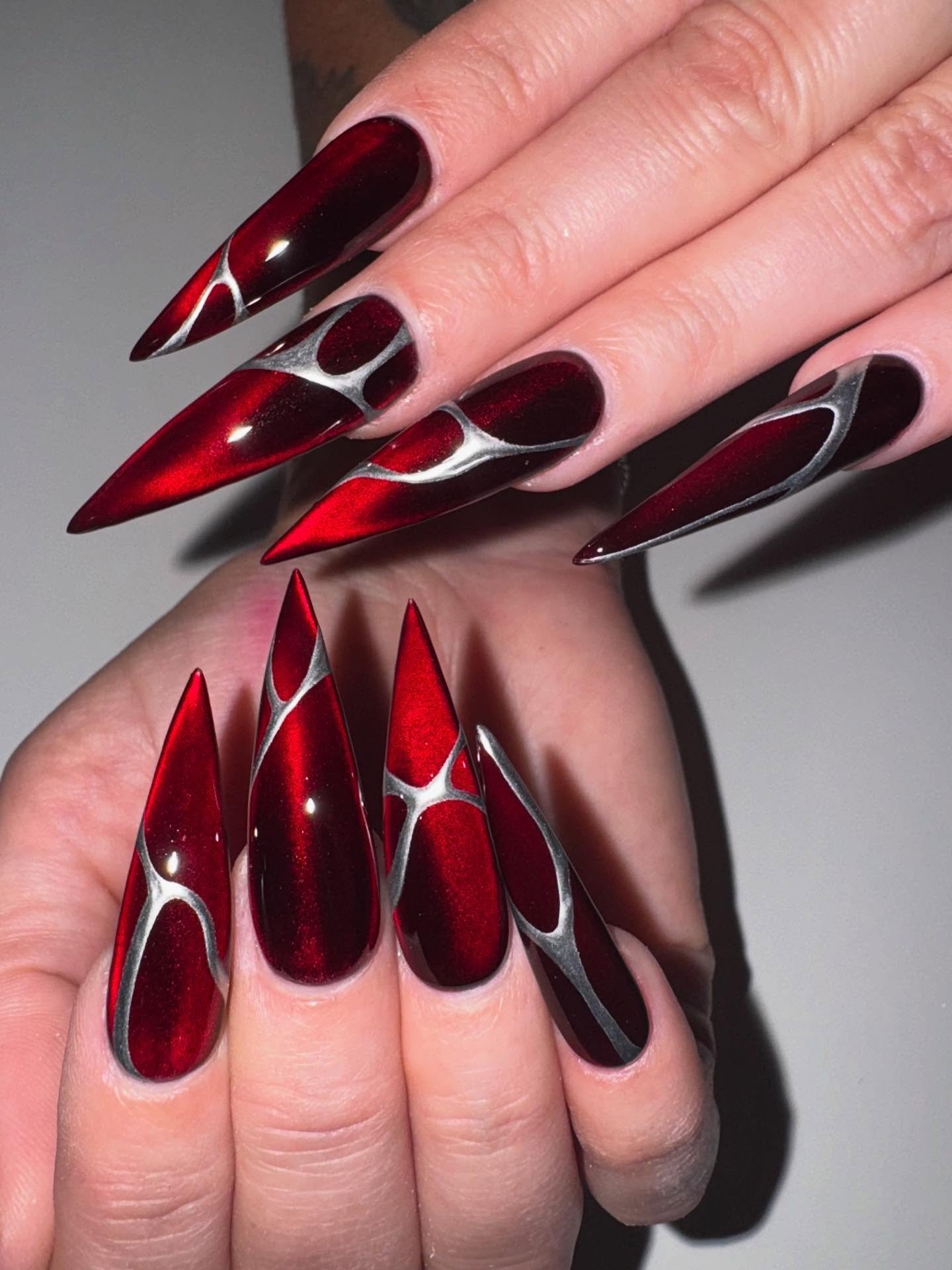 Glossy Red and Black Stiletto Nails with Silver Accents