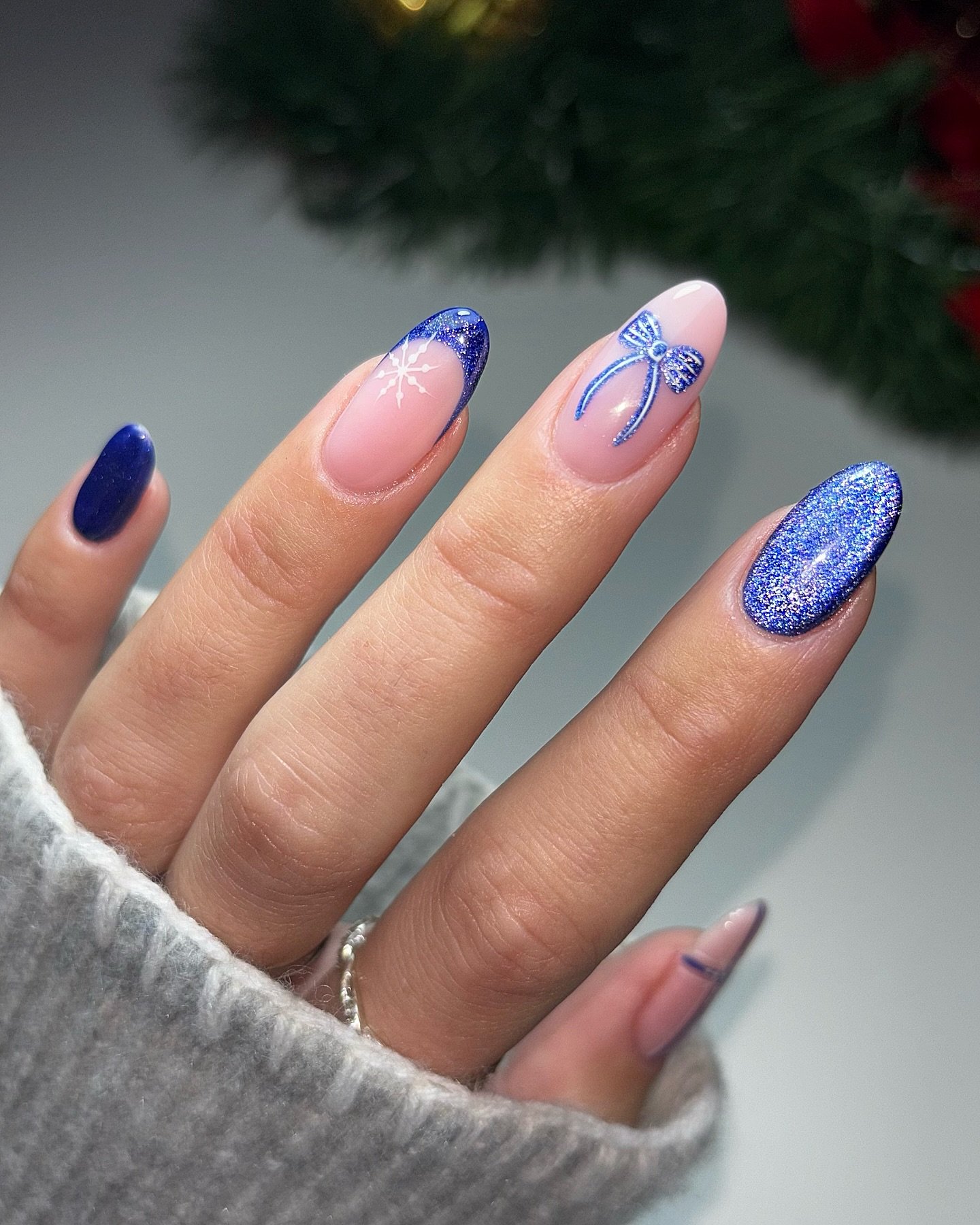 Blue Christmas nails idea 15: Pink Almond Nails with Blue French Tips and Sparkle