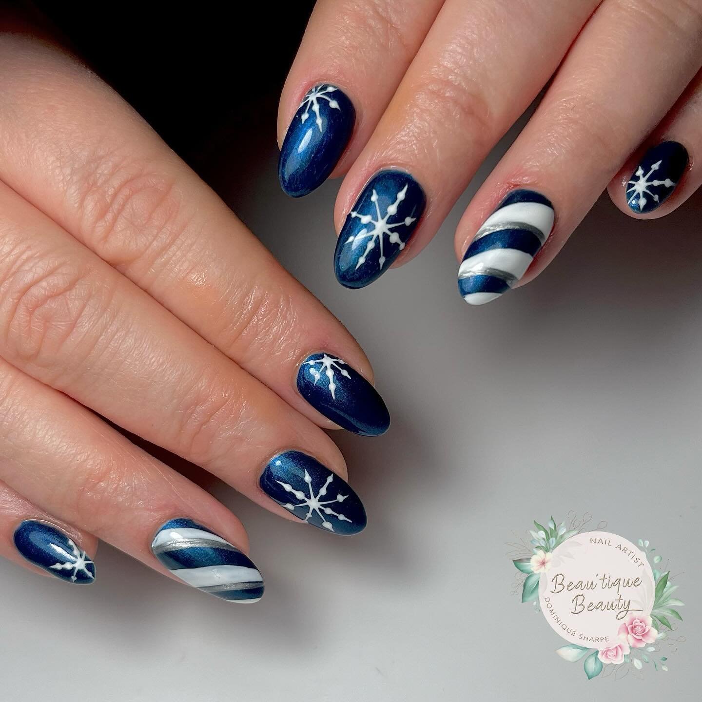Blue Christmas nails idea 18: Navy and White Almond Nails with Snowflakes and Stripes