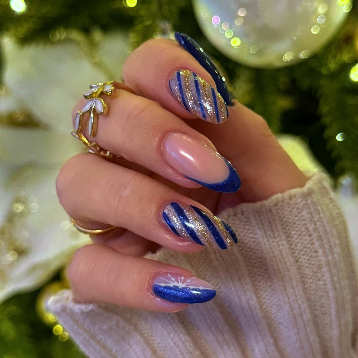 Blue Christmas nails idea 21: Blue Glitter Almond Nails with Pink Bases and Curved Line Art