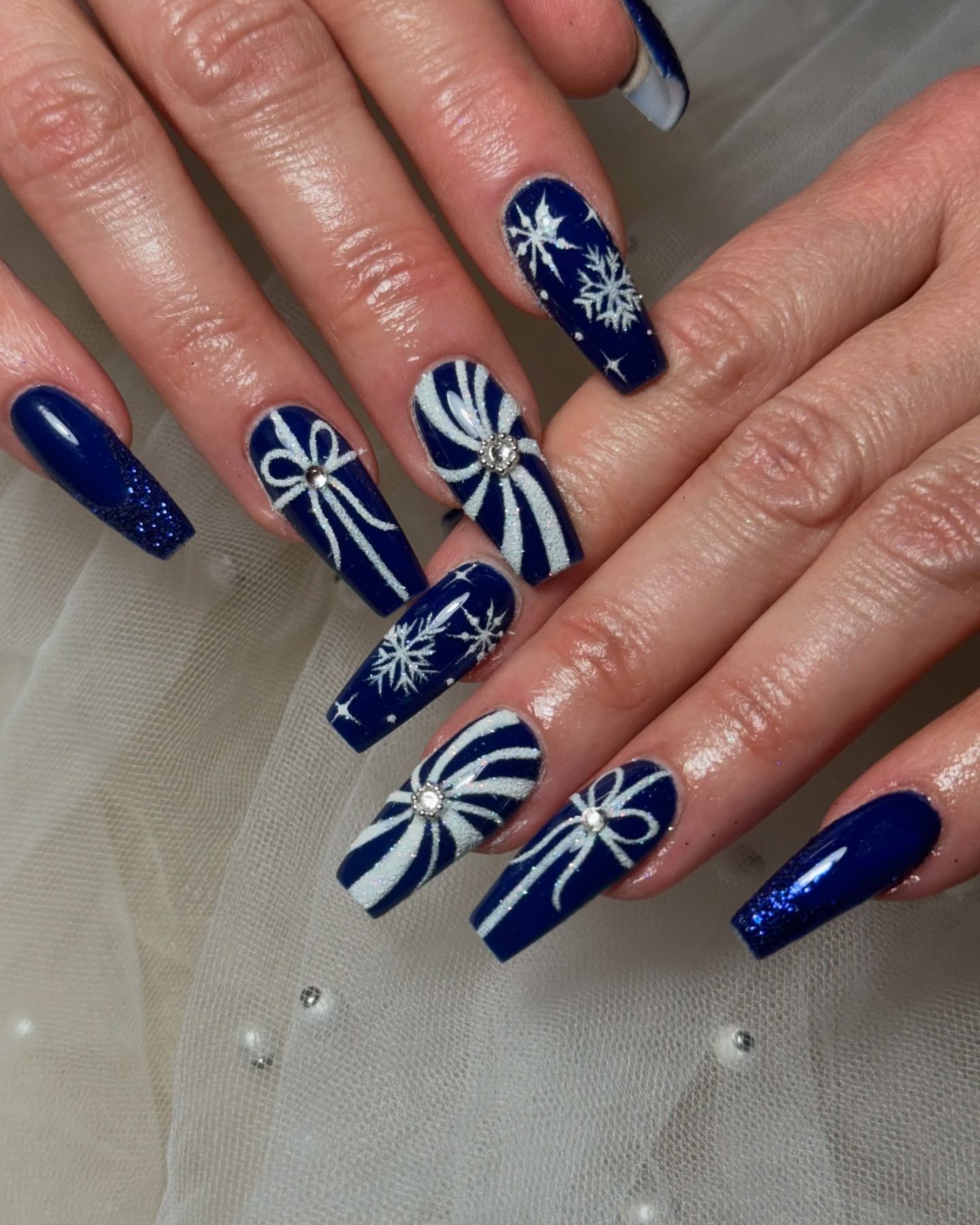 Blue Christmas nails idea 29: Navy Christmas Nails with White Bows and Snowflakes