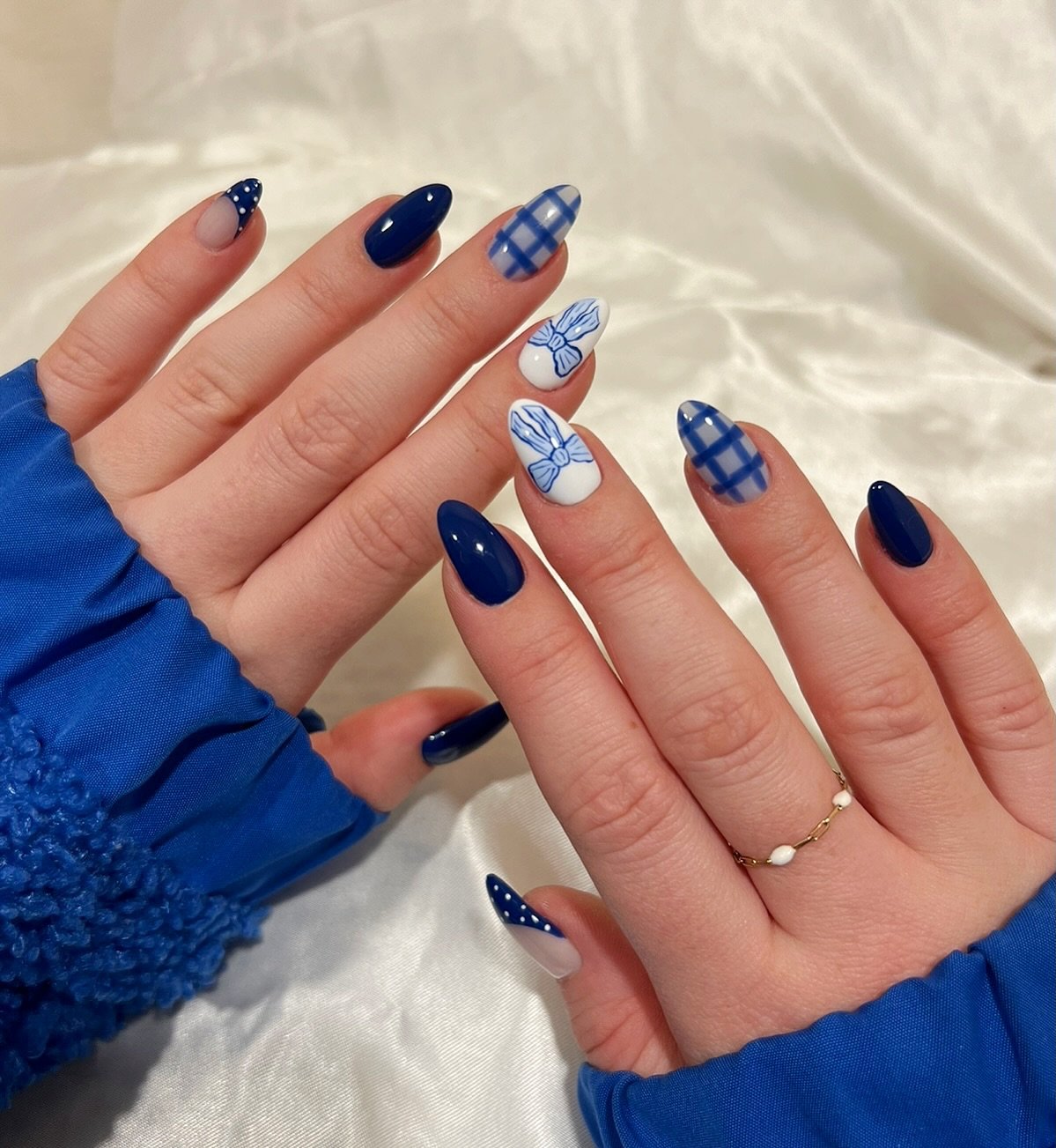 Blue Christmas nails idea 34: Navy and Nude Almond Nails with Blue Plaid and Snowflakes