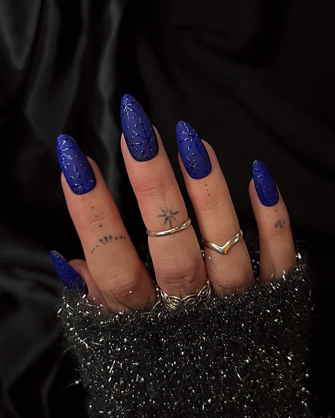 Blue Christmas nails idea 35: Deep Blue Textured Almond Nails with Subtle Sparkle