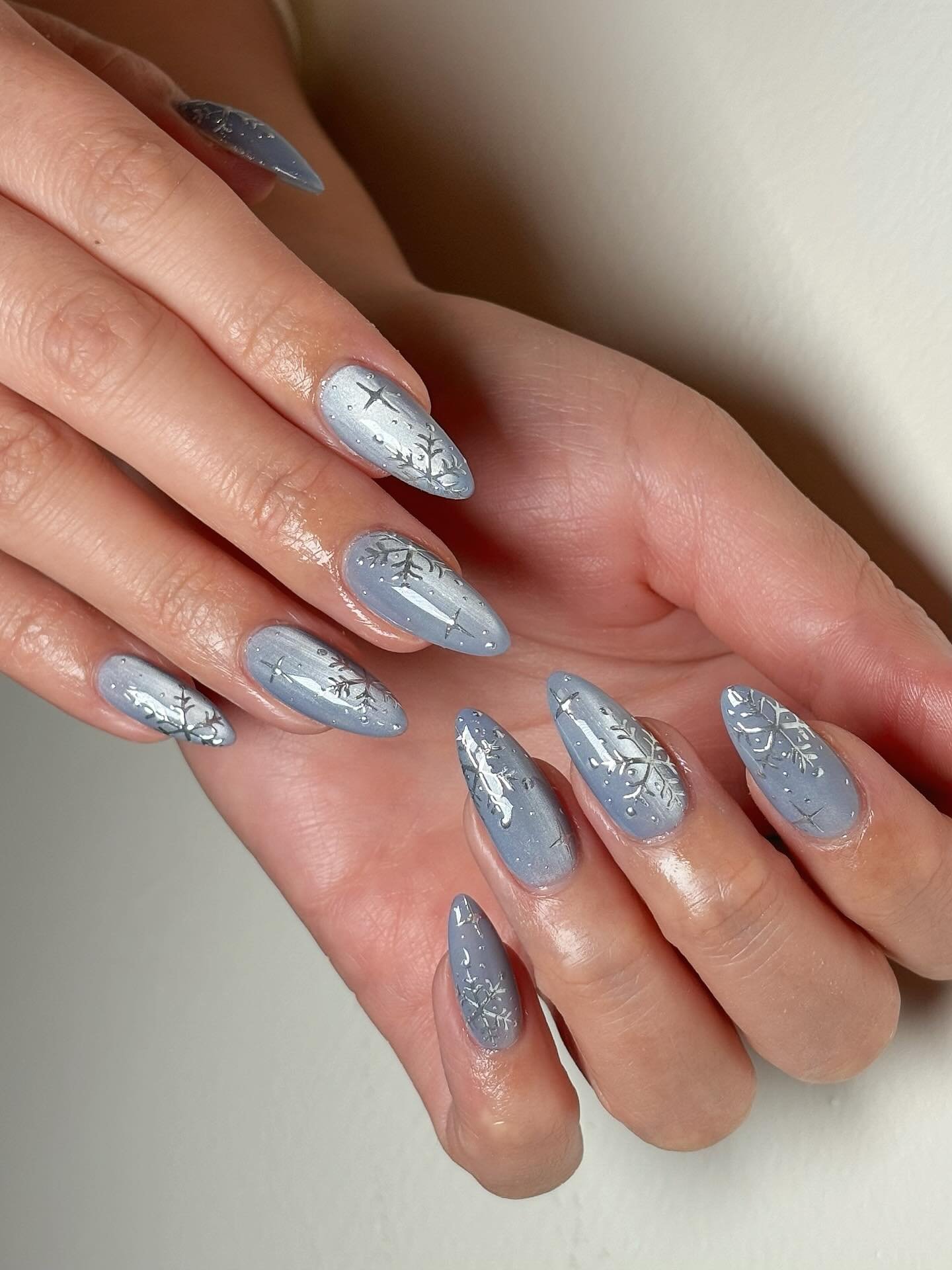 Blue Christmas nails idea 39: Silver-Blue Glitter Almond Nails with Fine Winter Details