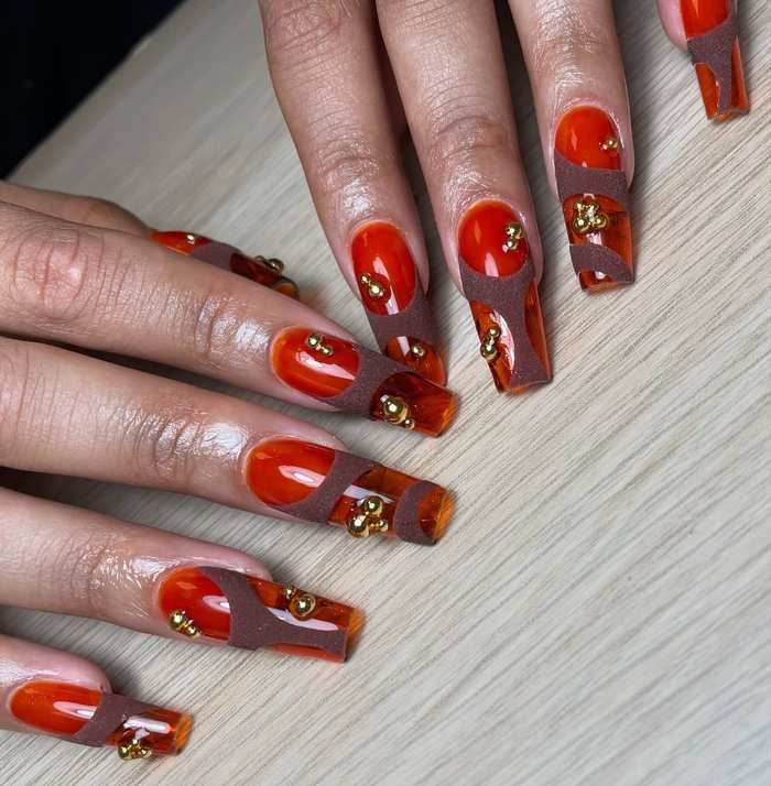 Red and Orange Graphic Almond Nails with Gold Accents