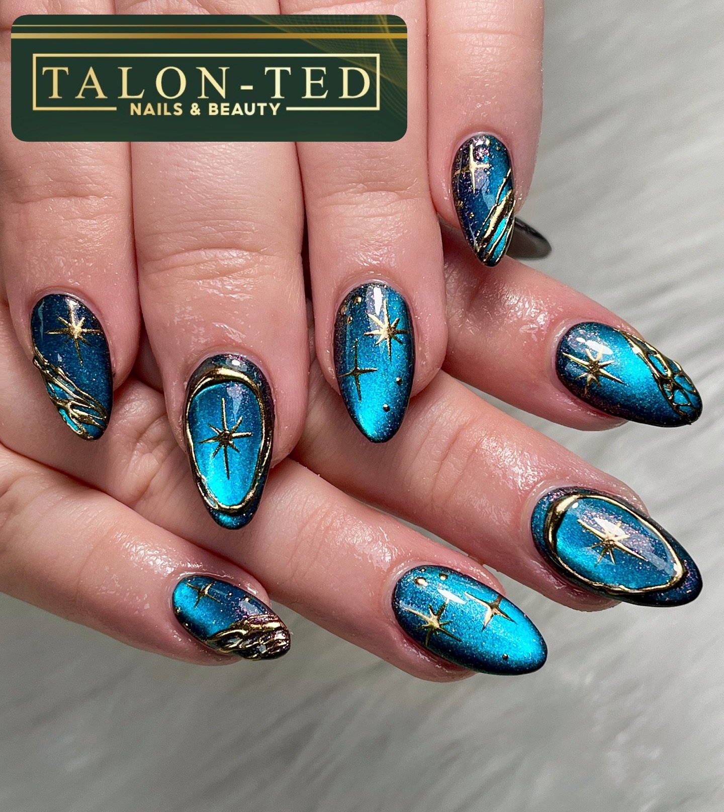 Vivid Blue Chrome Almond Nails with Gold Details — DWo-fxXjAO7Talonted Nails & Beauty.jpg