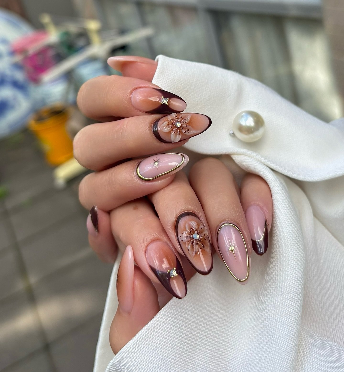 Long Almond Pink Nails with Chocolate French Tips and Floral Accents