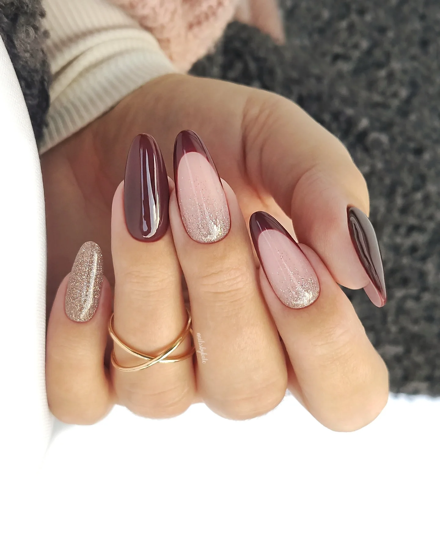 Medium almond nails mix chocolate brown, blush pink, and cream shades with striped and textured accent designs.