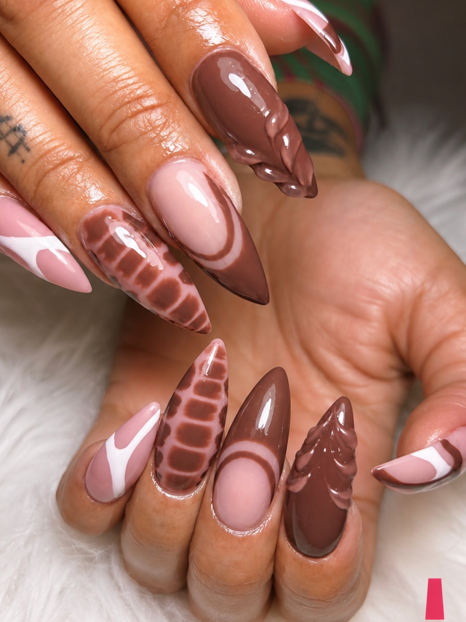 Long almond nails combine chocolate French tips with checkerboard, striped, and animal-inspired accent patterns.