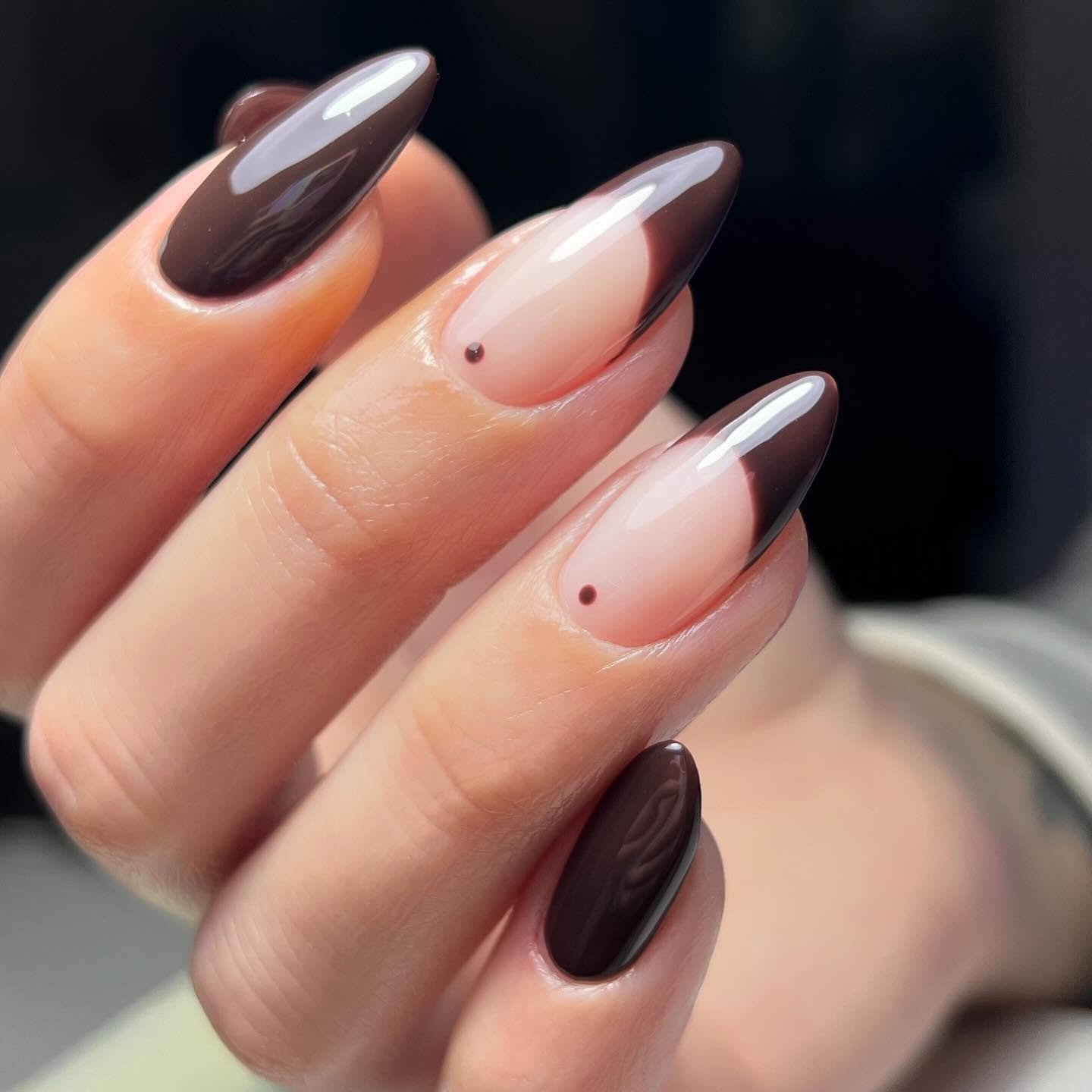 Long almond nails use a glossy pink-nude base with deep chocolate-brown French tips.