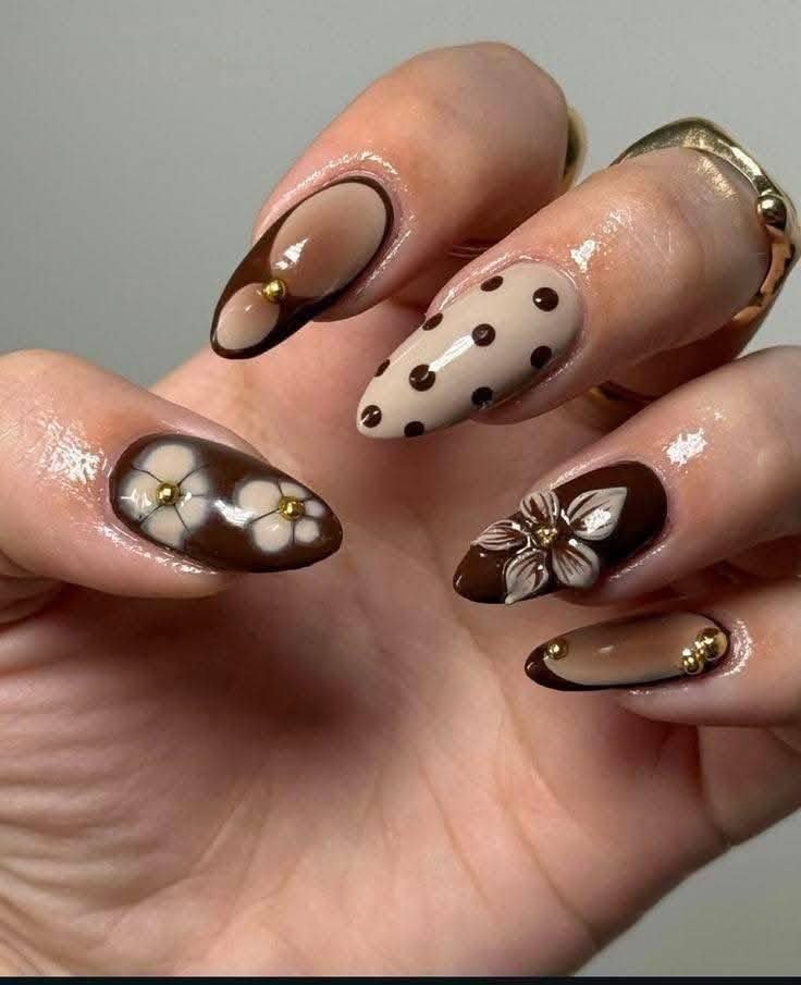 Medium almond nails mix chocolate French details with tortoiseshell-style accents, small white dots, and floral-like motifs.