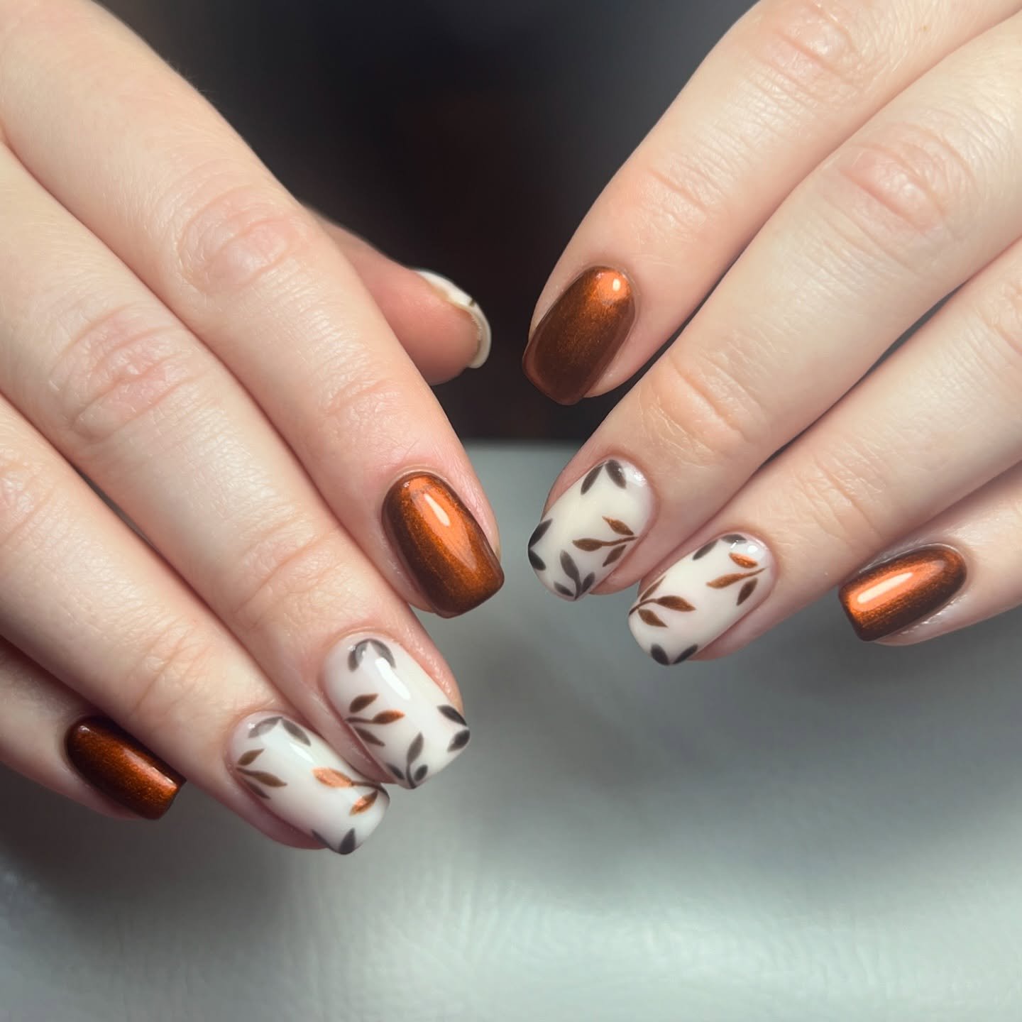 Brown Chrome Almond Nails with White Leaf Art