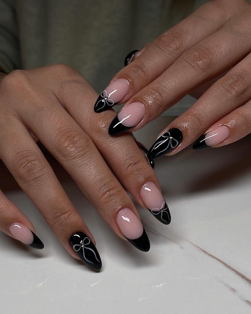 Nude Almond Nails with Black French Tips and Small Accents