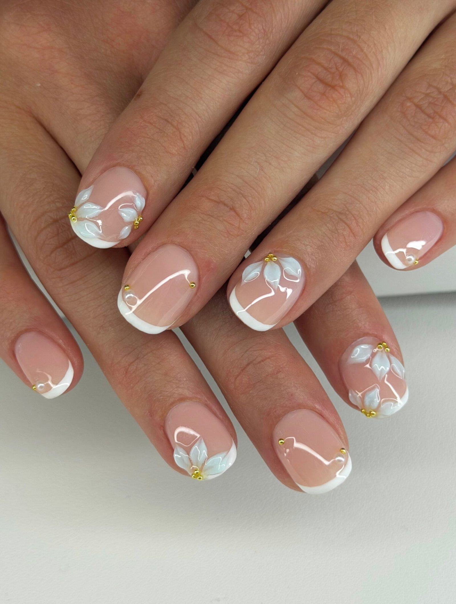 Short Nude Nails with White Floral Details and Gold Accents