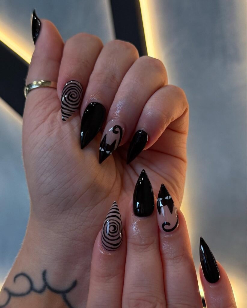 Glossy Black Almond Nails with Swirls and Tiny White Accents