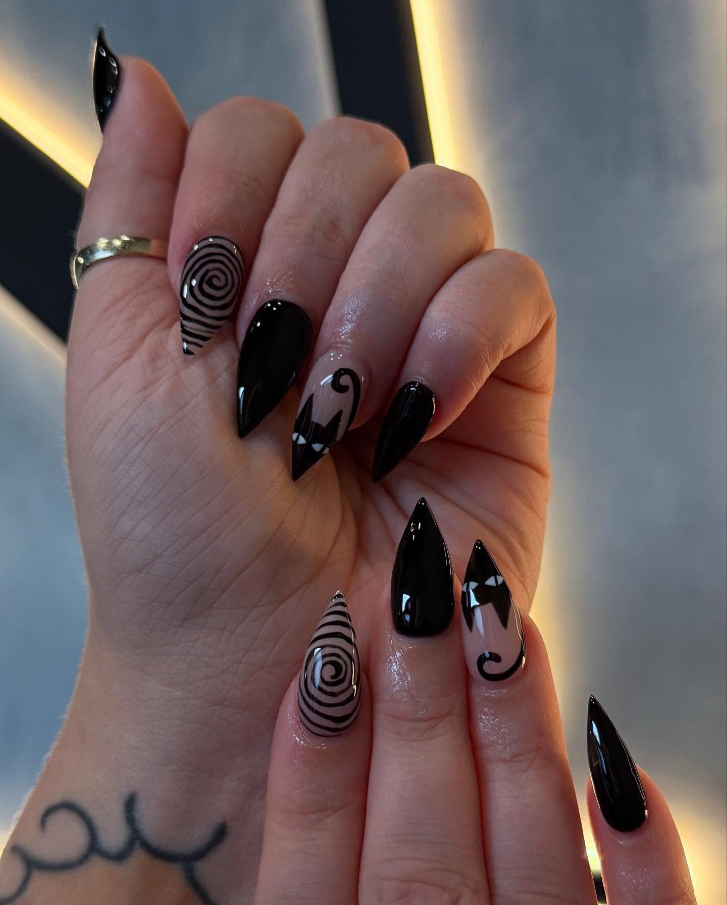 Glossy Black Almond Nails with Swirls and Tiny White Accents