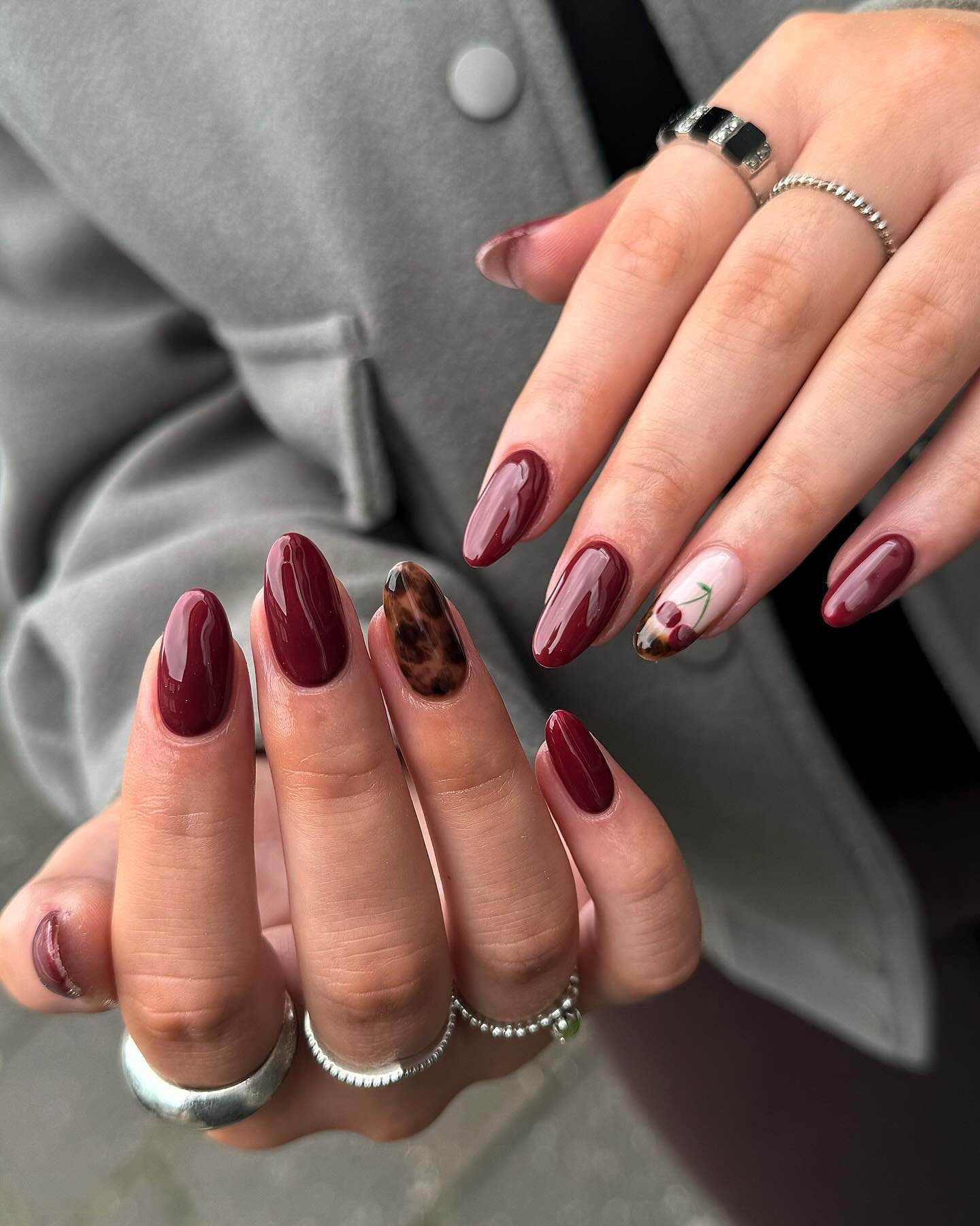 Burgundy almond nails with nude French-style accents