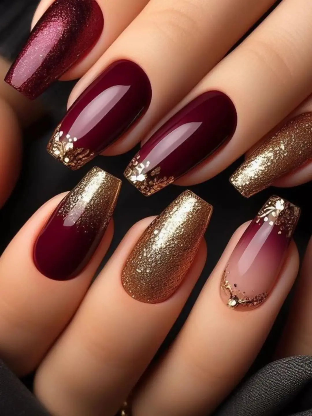 Burgundy almond nails with gold glitter accents