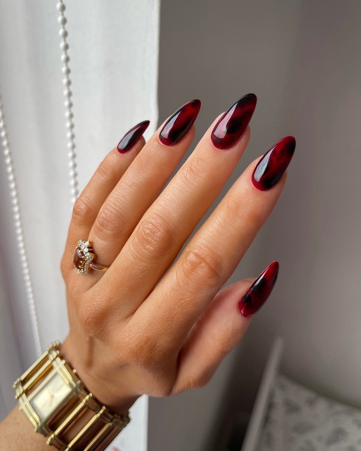 Deep burgundy almond nails with a glossy finish