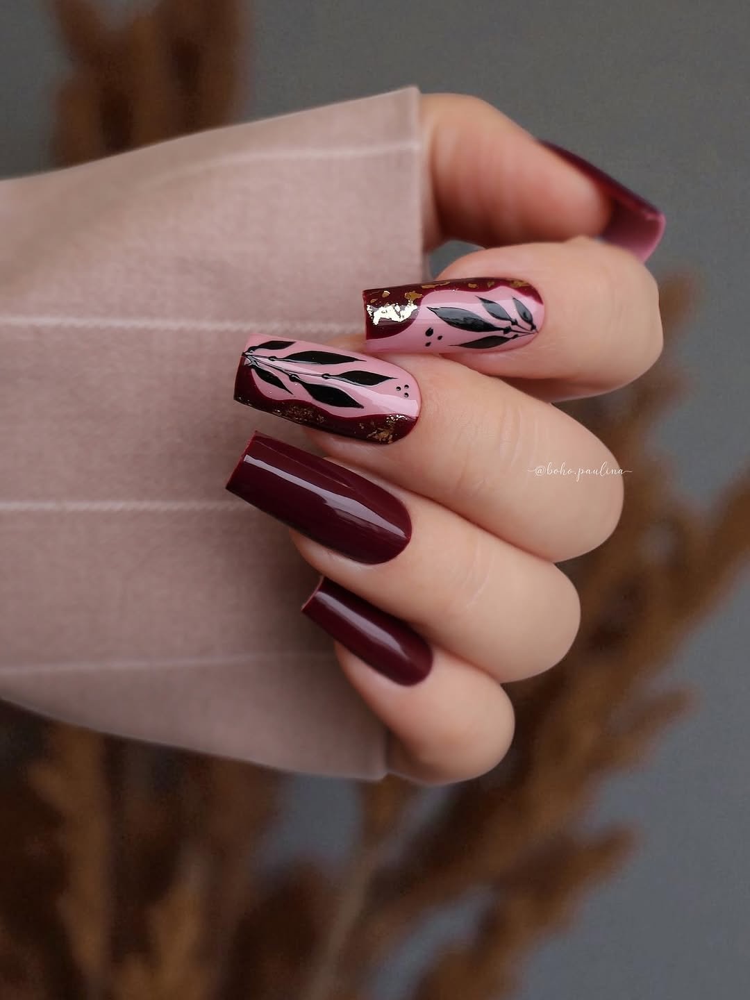 Burgundy almond nails with black-and-white abstract accents