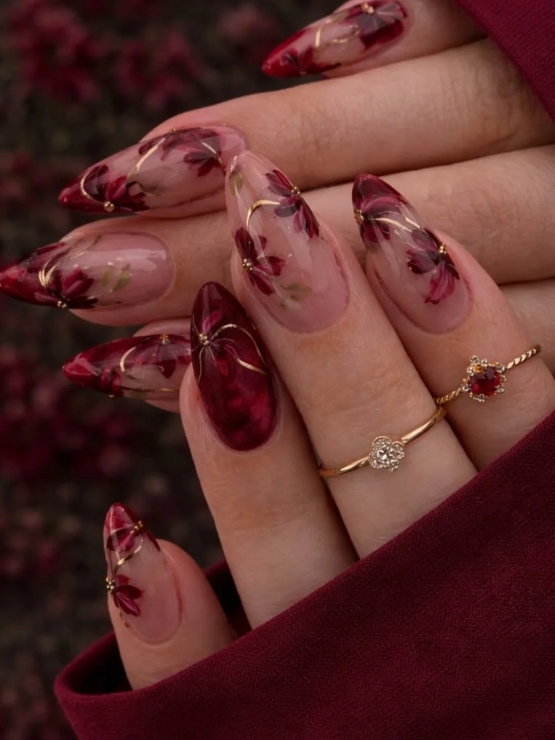 Sheer Red Almond Nails with Dark Floral Detailing