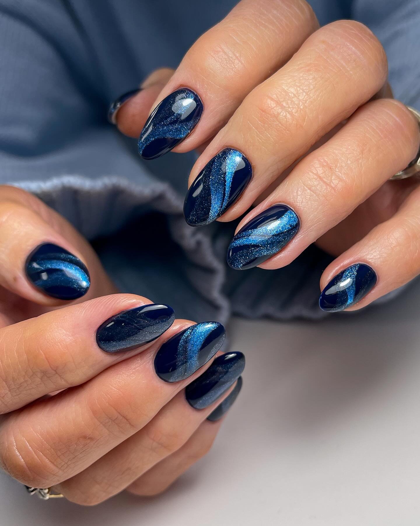 Glossy Blue Almond Nails with Metallic Accents