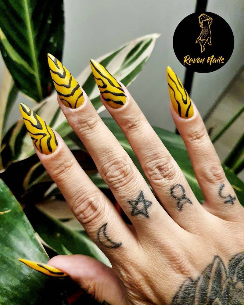 Yellow and Black Stiletto Nails with Striped Accents
