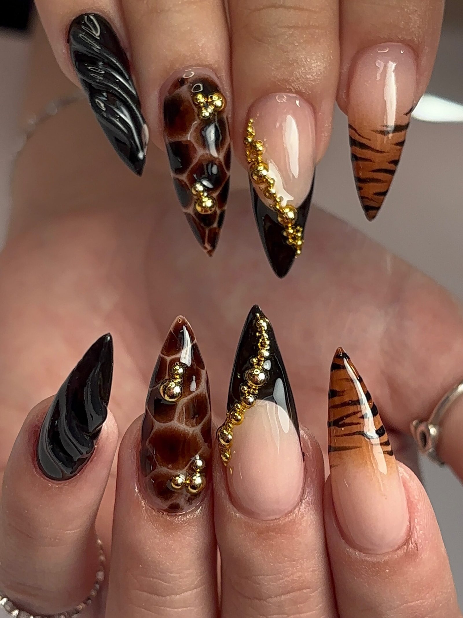 Black and Nude Stiletto Nails with Gold and Brown Accents