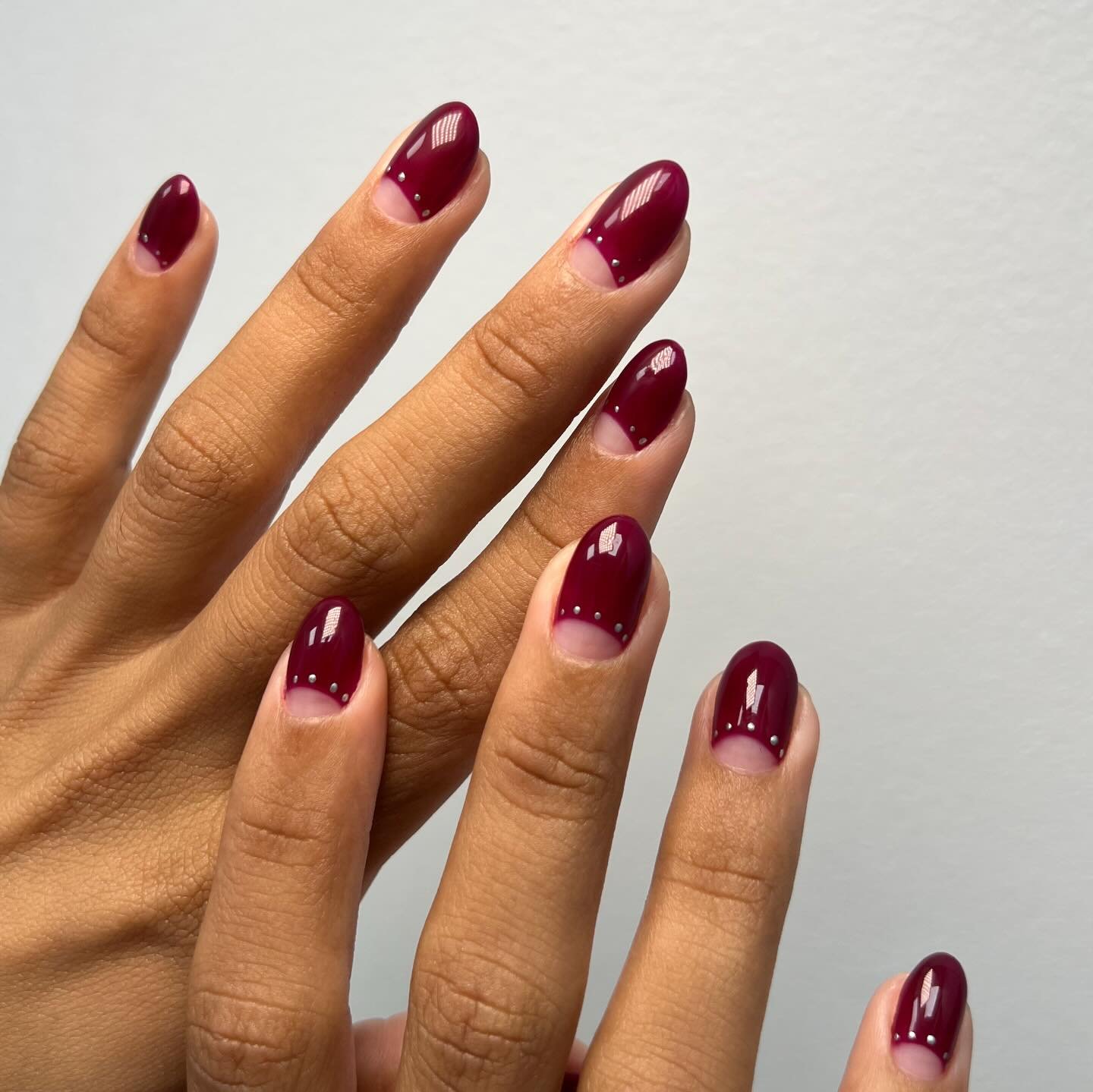 Burgundy Almond Nails with Soft Nude Half-Moons