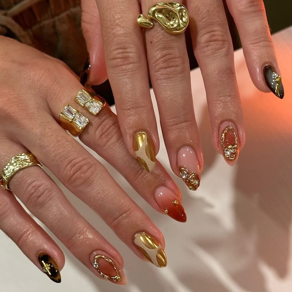 Long Nude Nails with Gold and Brown Leaf Accents