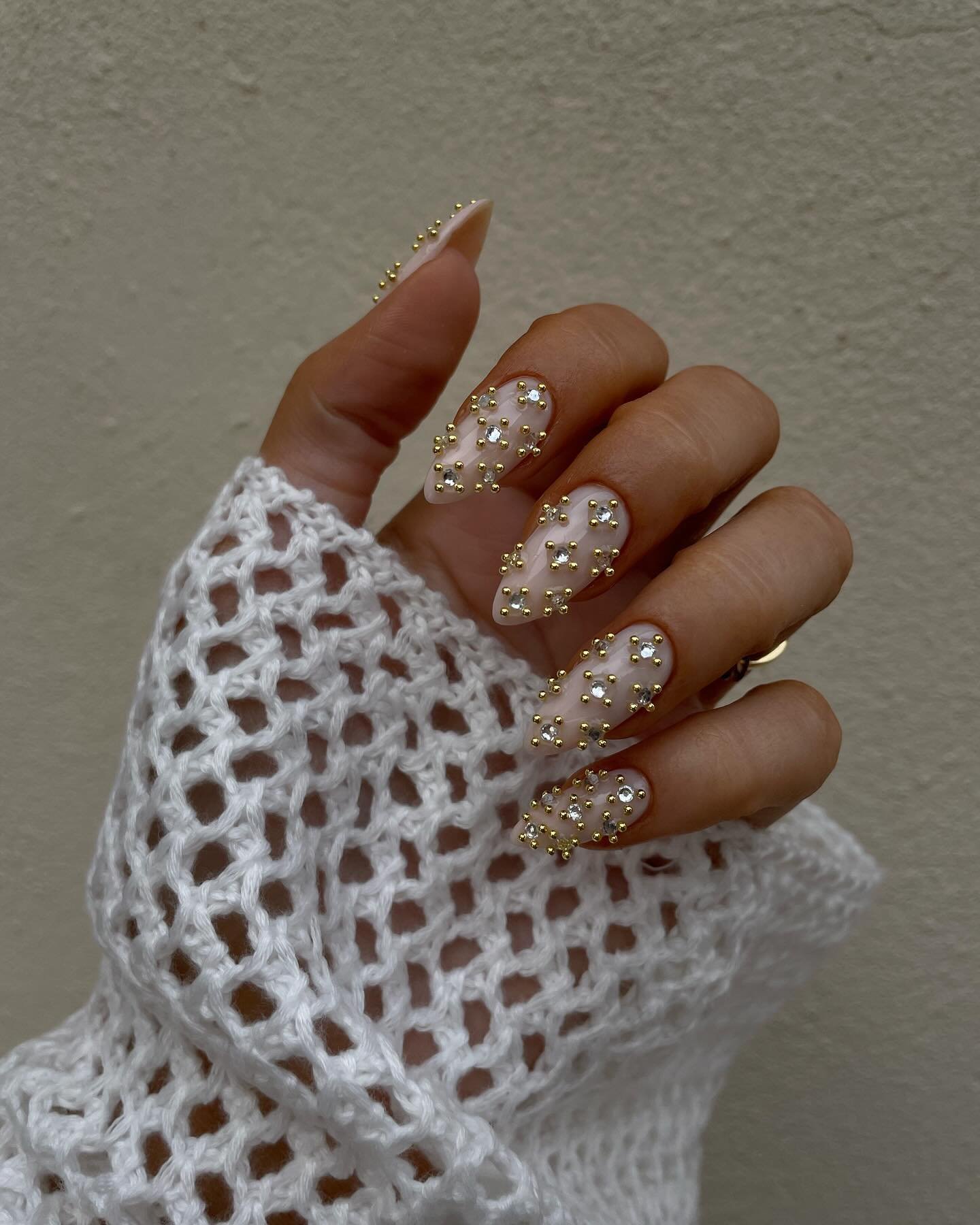 Long Nude Almond Nails with White Texture and Gold Details