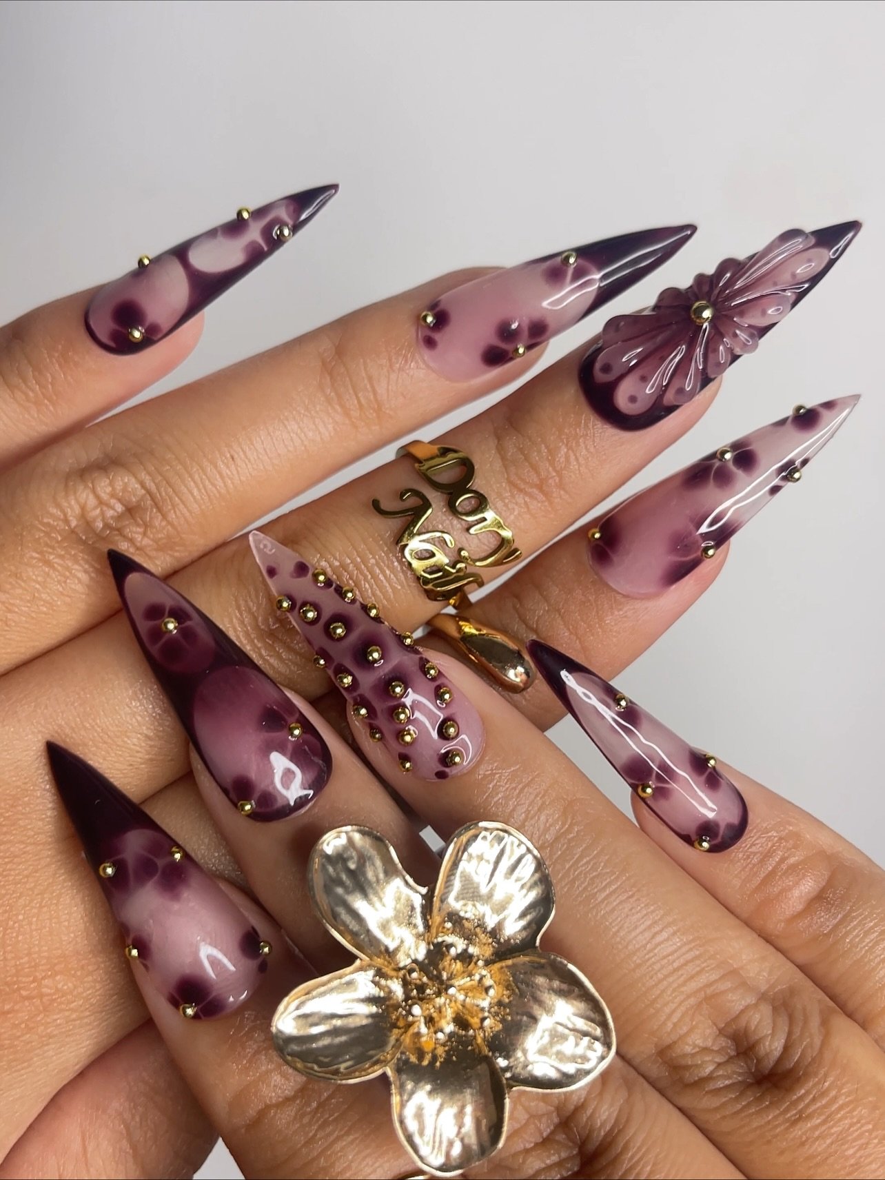 Mauve Stiletto Nails with Purple and Gold Embellishments