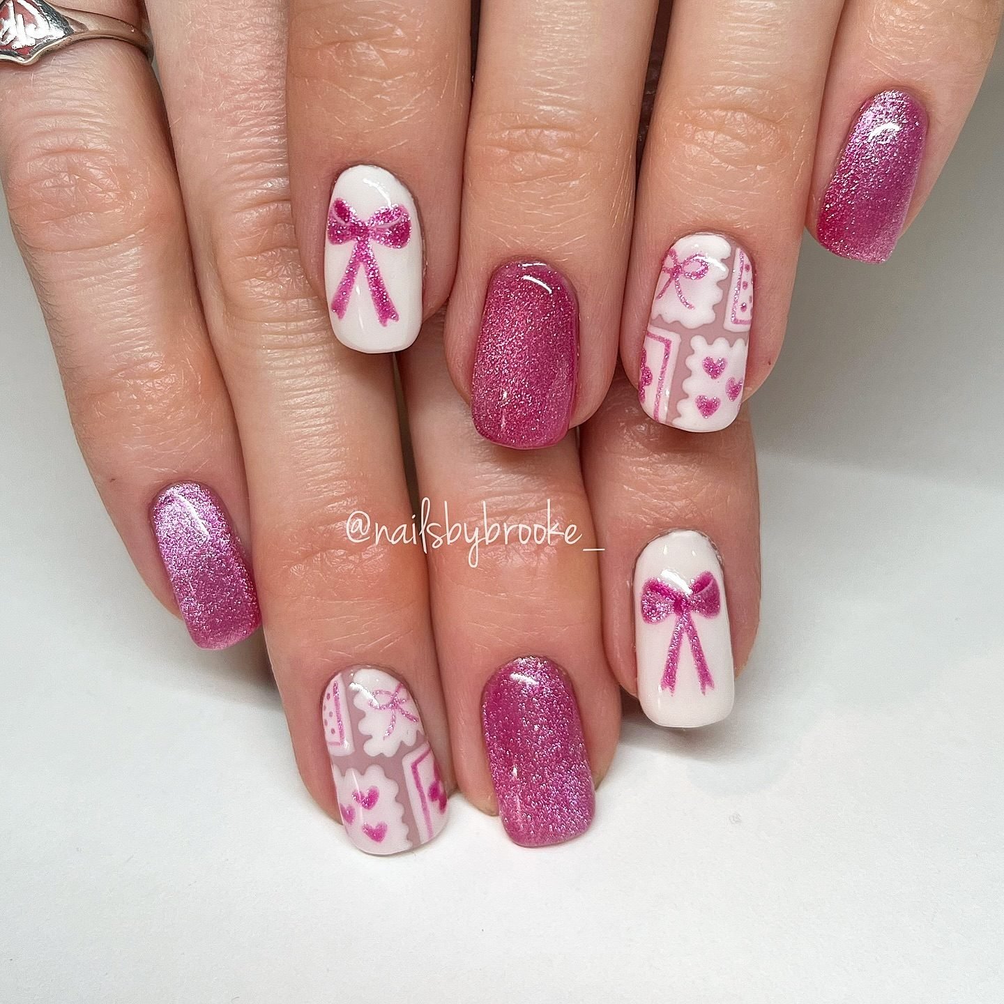 Short Pink Nails with White Floral and Bow Details