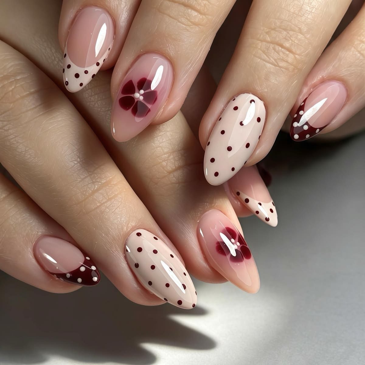 Almond Nude Nails with Brown Polka Dots and Burgundy Floral Accents
