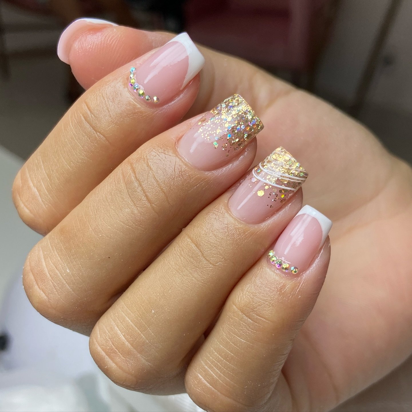 French-Tip Nails with Gold Glitter and Rhinestone Accents