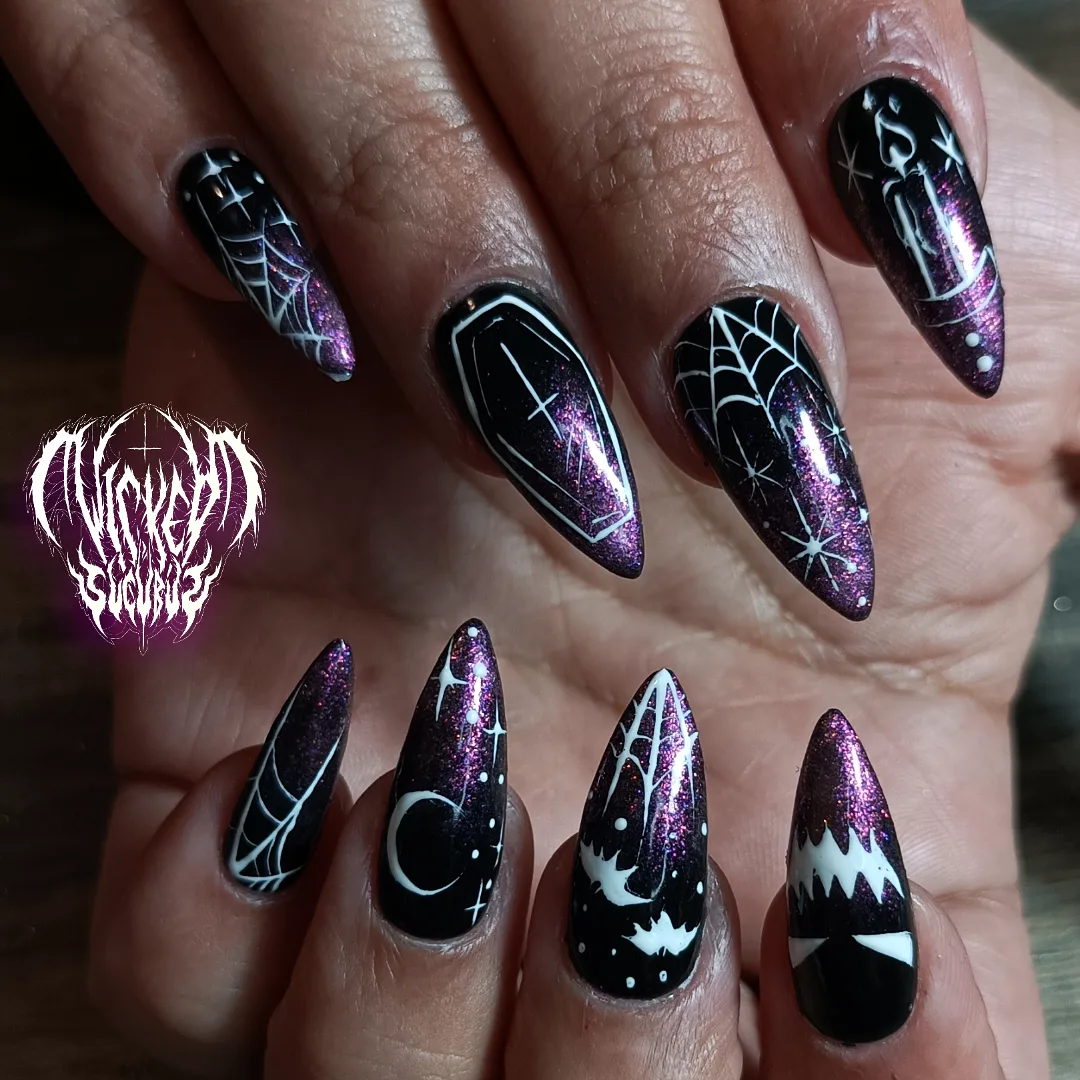 Black pointed nails mix purple accents with spiderwebs, a crescent shape, and other small Halloween motifs.