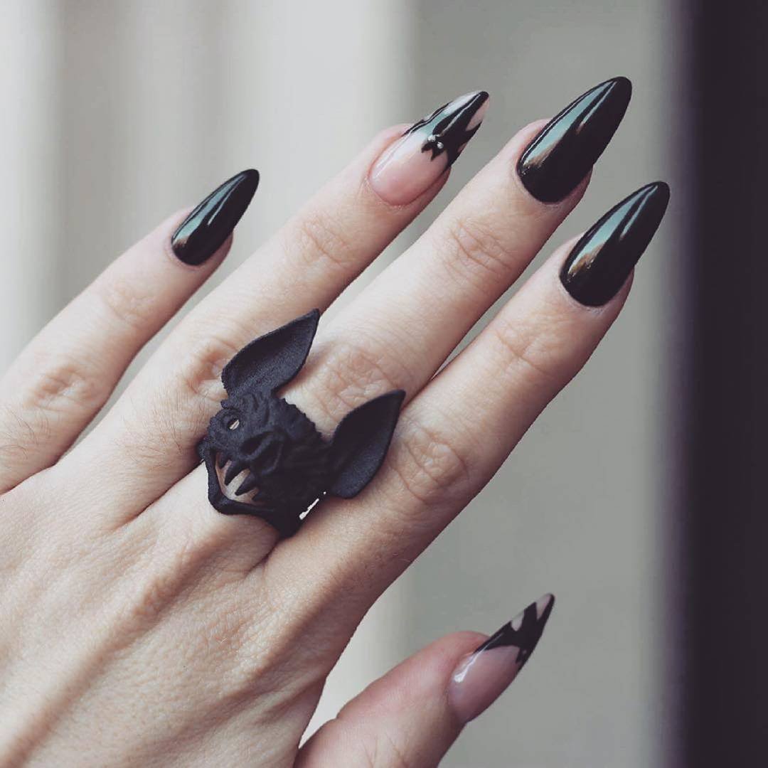 Long almond nails have a dark black finish with subtle reflective color along the edges.