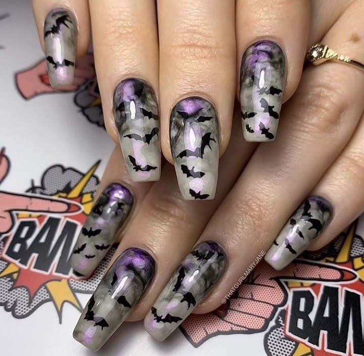 Medium-length coffin nails combine gray, white, black and purple with illustrated monster-like faces and distressed details.