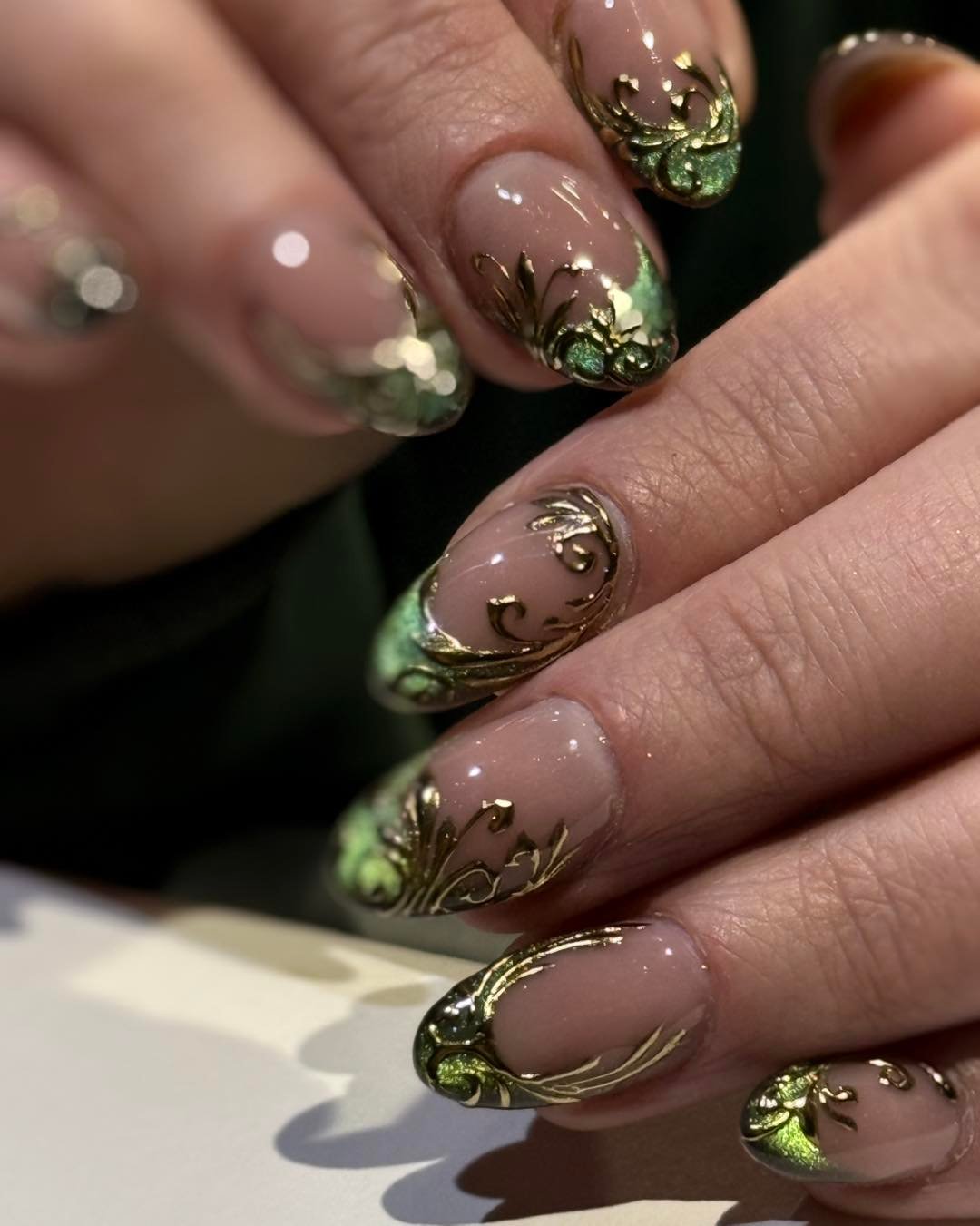 Green Nails with White Floral Accents and Gold Details