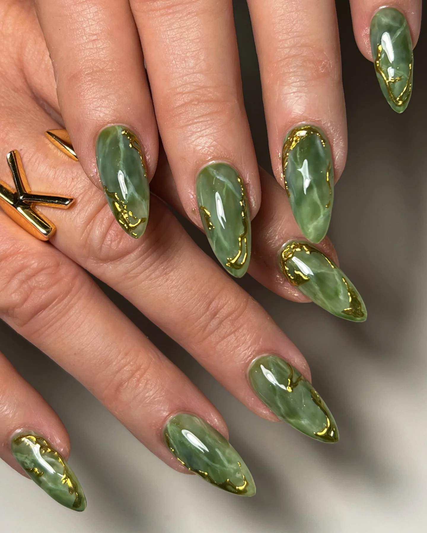 Jewel-Toned Green Nails with Gold Embellishments