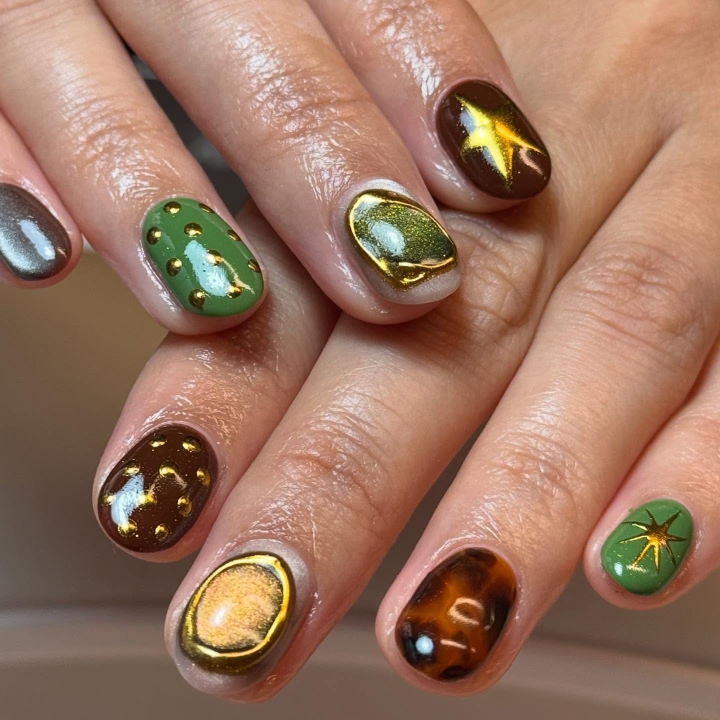 glossy green nails with brown and gold accents