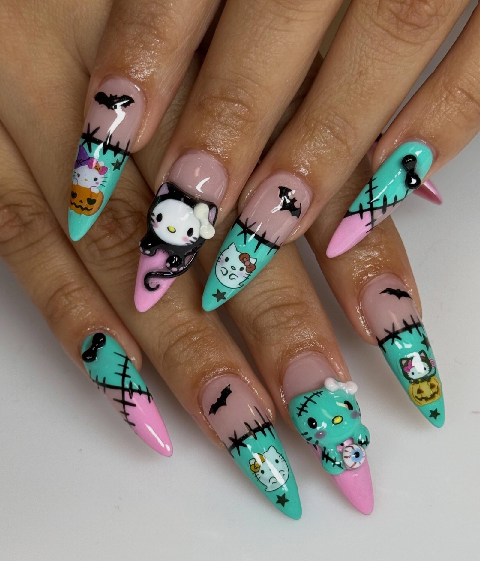 Turquoise and pink Halloween nails with ghosts, pumpkins, bats, and stitch details.