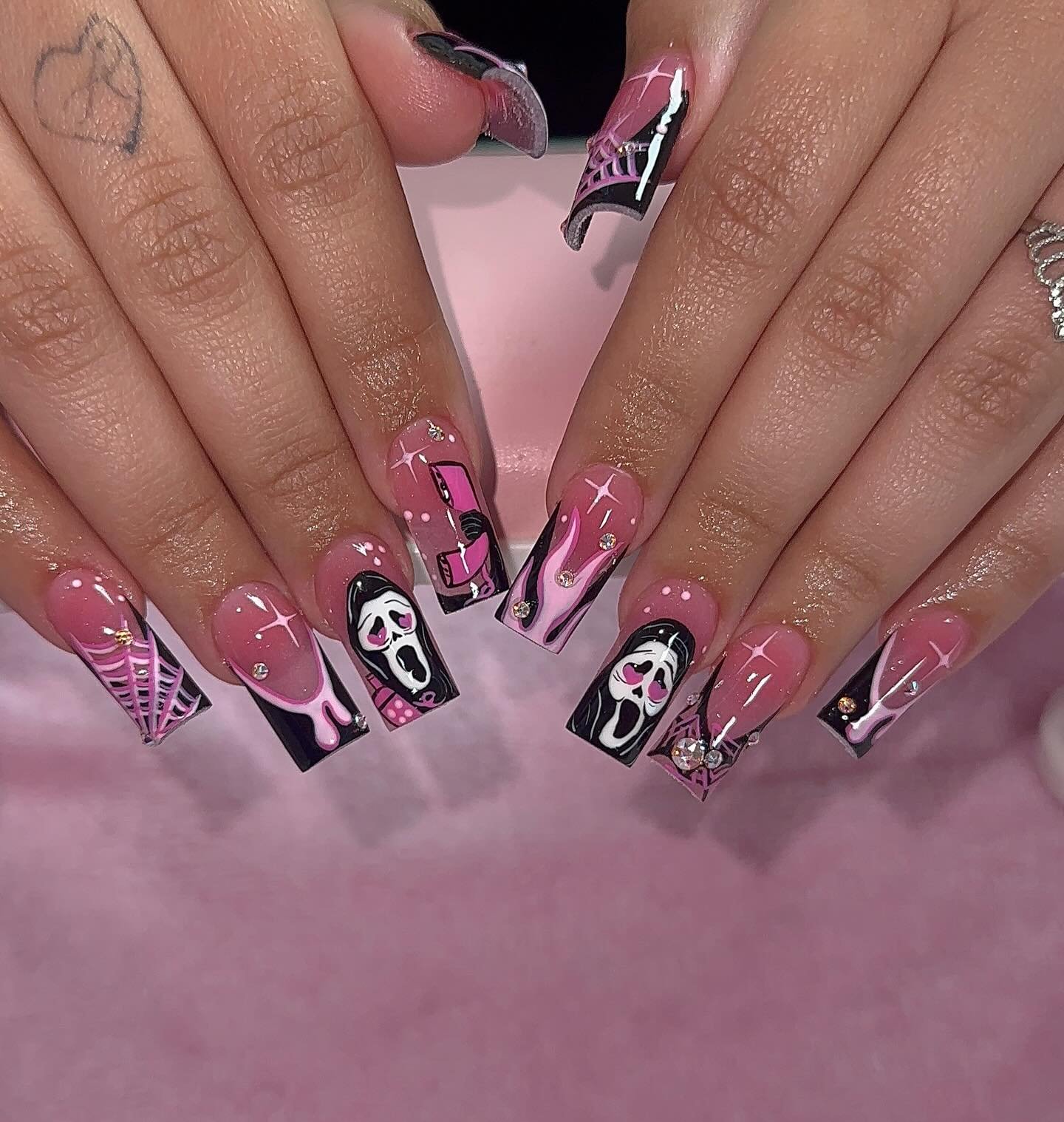 Pink and black square Halloween nails with Ghostface faces, spiderwebs, and sparkle.