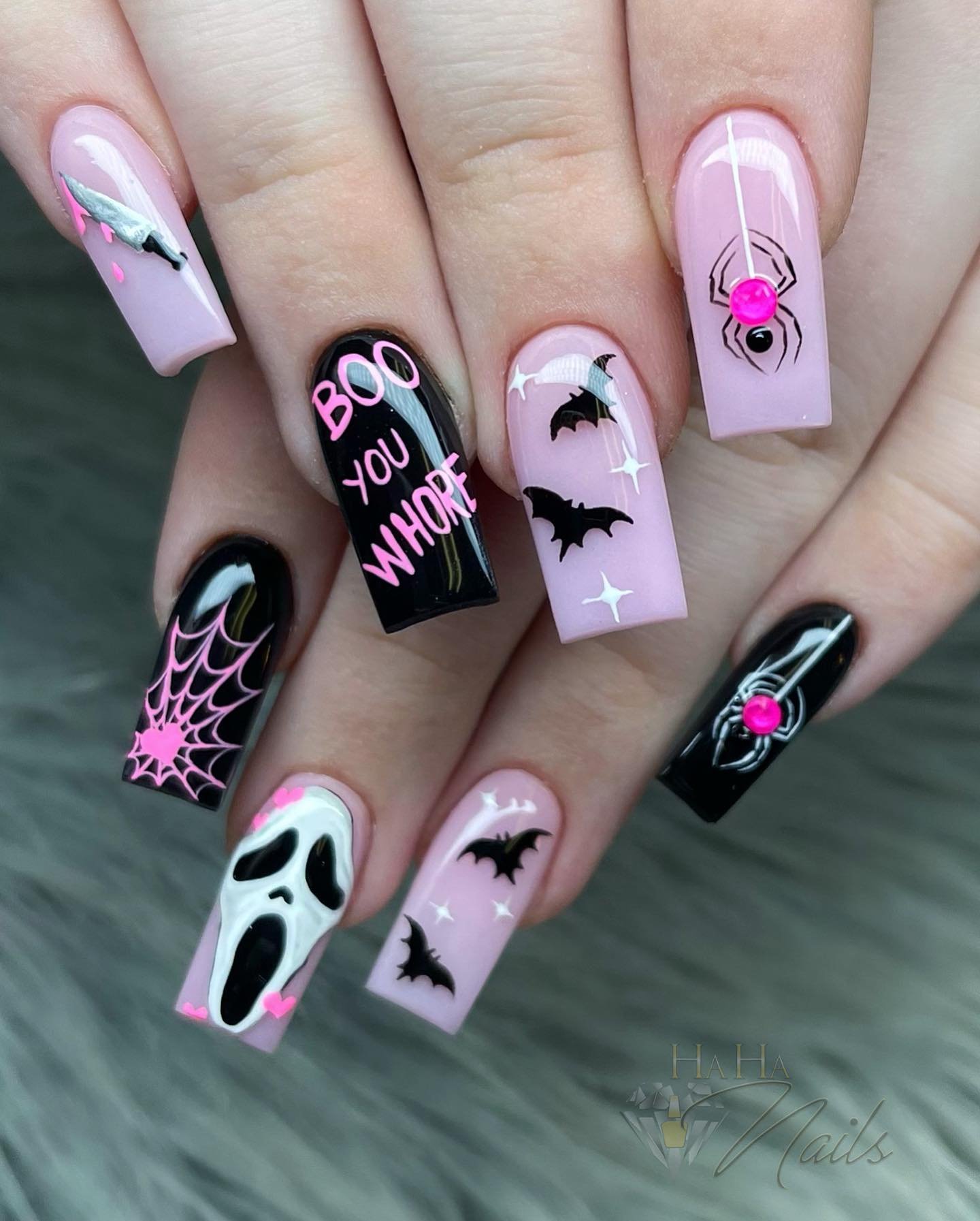 Pink and black square Halloween nails with BOO text, bats, a spider, and a ghost.
