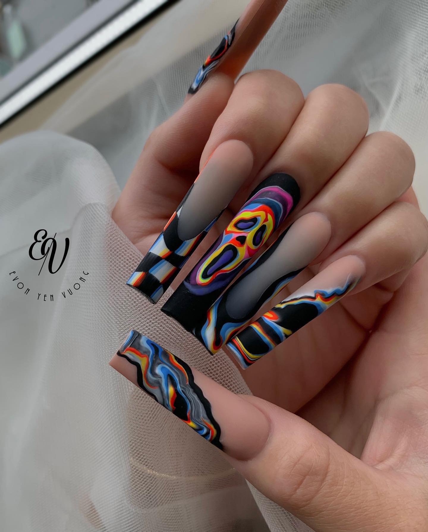 Matte black and nude coffin nails with colorful psychedelic swirl artwork.