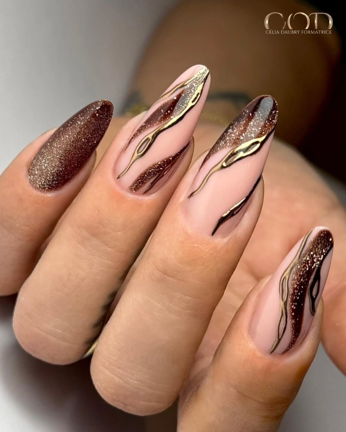 pink pointed nails with brown glitter and gold waves