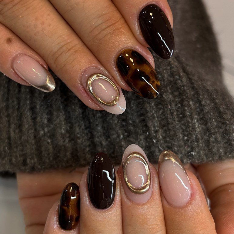 brown and nude almond nails with gold embellishments