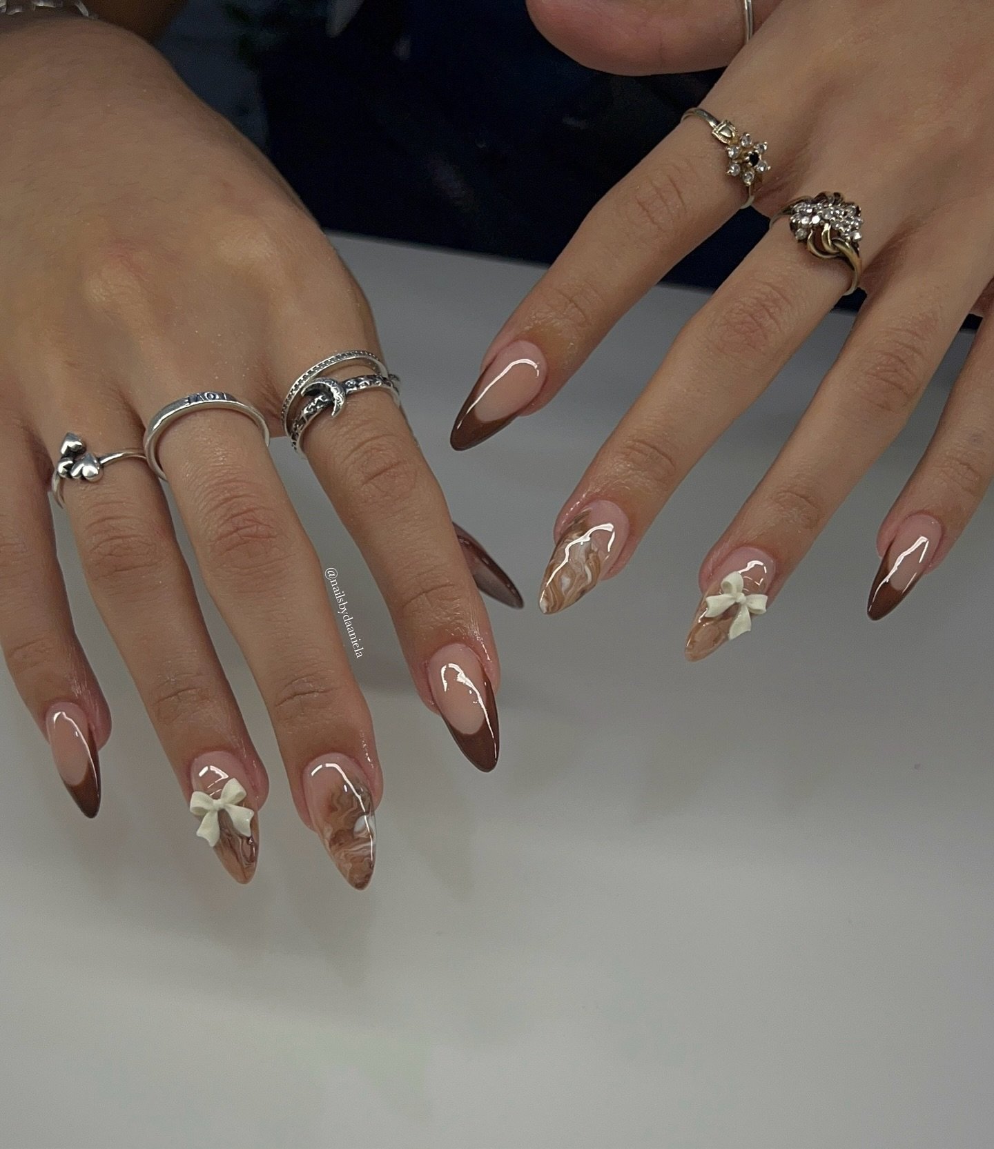 Sheer Nude Almond Nails with Brown Tips and Small Floral Accents