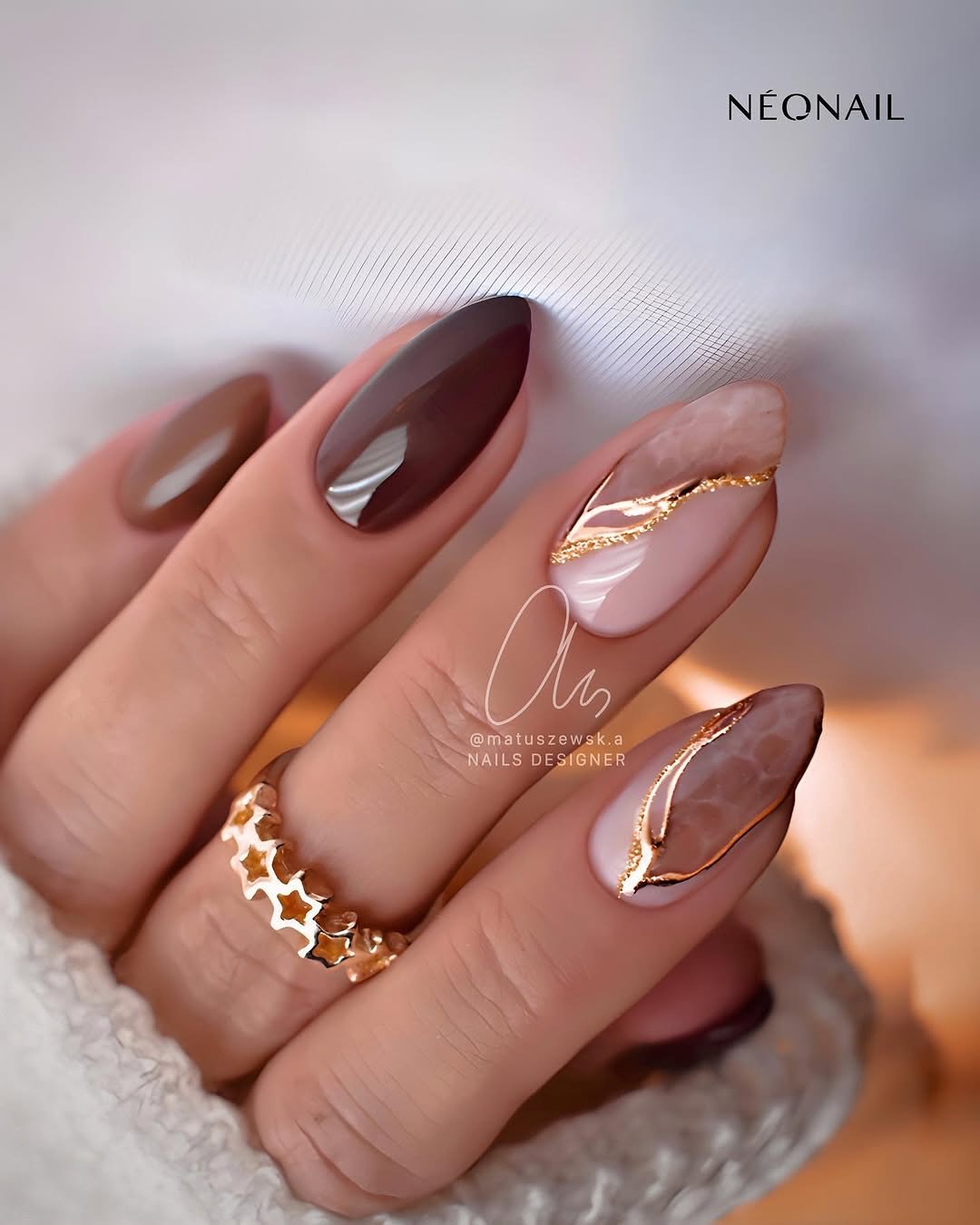 Glossy Taupe Almond Nails with Gold and Brown Curved Accents
