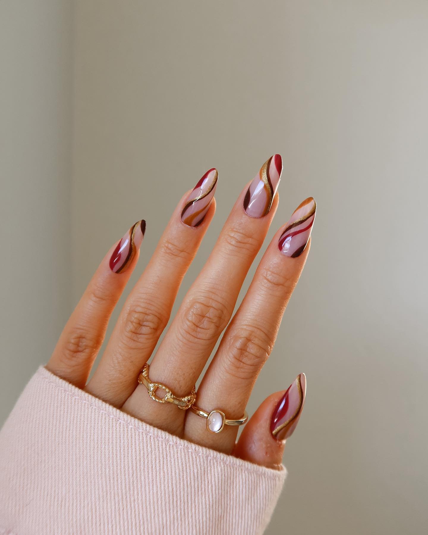 Long Nude Almond Nails with Burgundy, Orange, and Green Curves